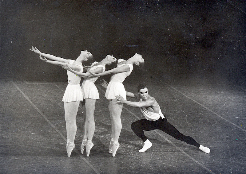 Three female ballet dancers stand on pointe with the heads back while Jacques extends into a lunge behind them